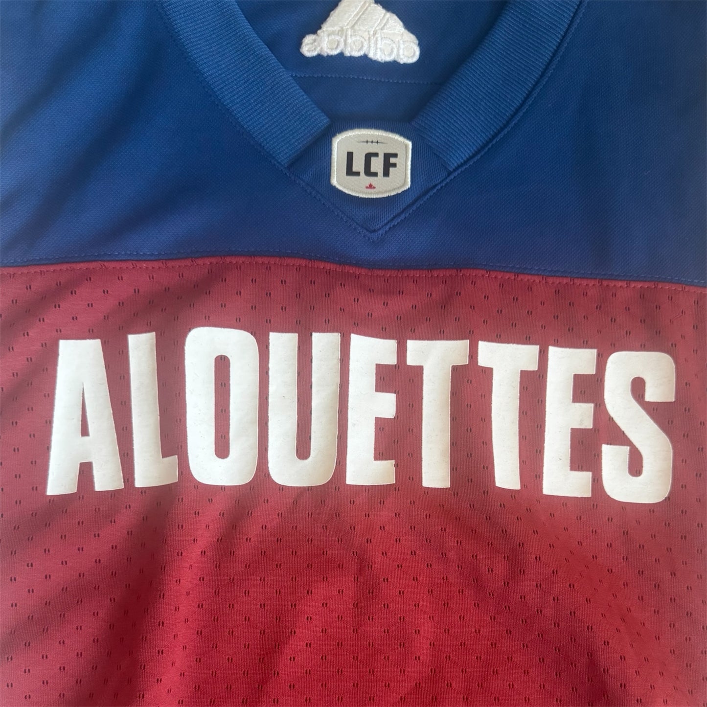 Montreal Alouettes Adidas CFL home jersey, front logo close-up